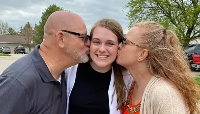 Carly Holbrook poses for a photo with her parents